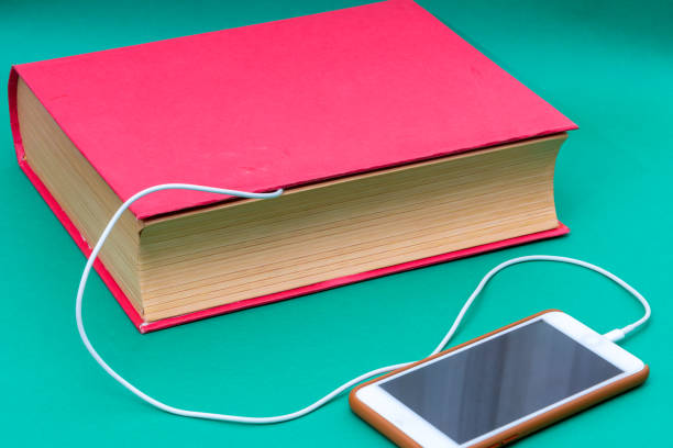 istock Mobile phone reading big book under the charge condition 1208573829