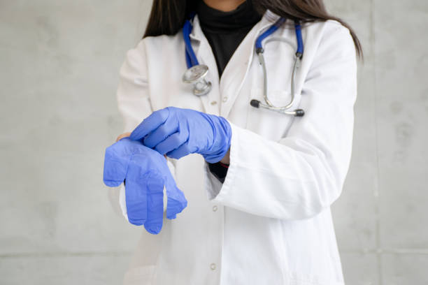 istock Doctor putting on examination gloves. 1208573836