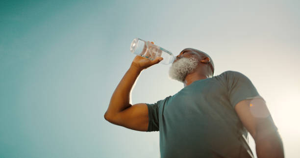 zorg ervoor dat je gehydrateerd bent na het sporten - drinking water stockfoto's en -beelden