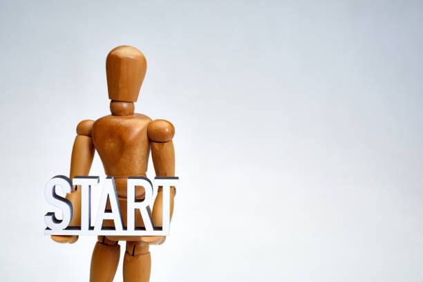 istock Wooden artist's figure holding text start 1208576650