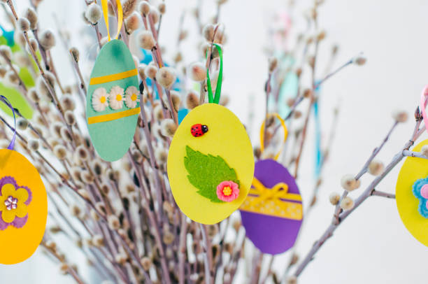 istock Easter eggs cutted from color paper decorated with ribbon and buttons on willow branches 1208576756