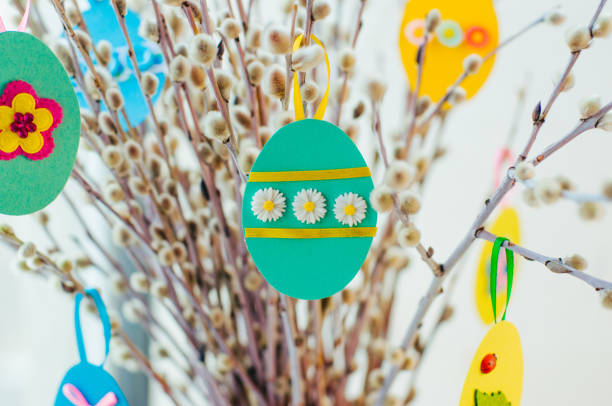 istock Easter eggs cutted from color paper decorated with ribbon and buttons on willow branches 1208576791