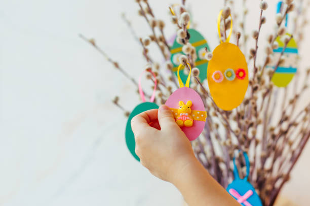 istock Close up of child hanging Easter eggs cutted from color paper 1208576792