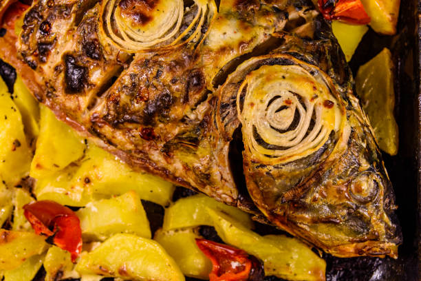 Baked carp fish with potatoes and bell pepper. Top view