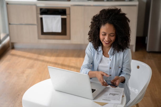 istock Woman paying her bills online through the banking app 1208577365