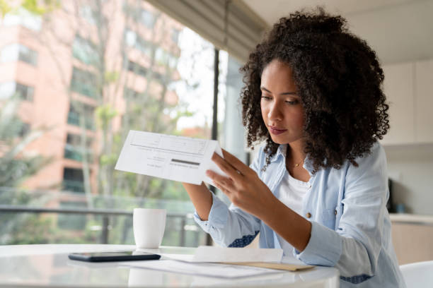 istock Woman looking at her bills after getting the mail at home 1208577742