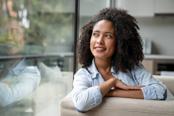 istock Thoughtful woman relaxing at home and looking through the window 1208577908