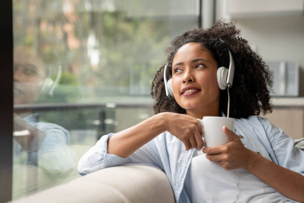 женщина дома пить кофе во время прослушивания музыки - chill out audio стоковые фото и изображения