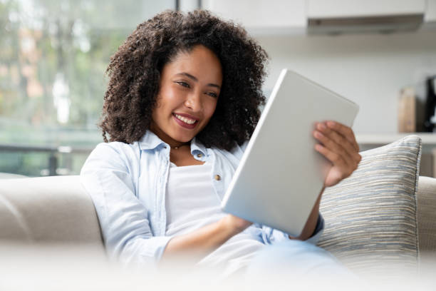 istock Happy woman using her tablet computer at home 1208577922
