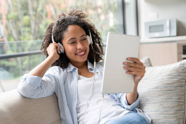 istock Woman at home watching videos online on a tablet computer 1208577971