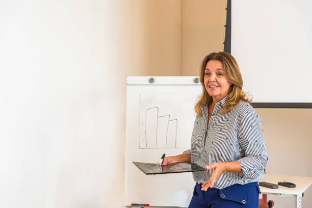 mujer brasileña haciendo presentación contenta en sala de reuniones - concentration teacher business copy space fotografías e imágenes de stock