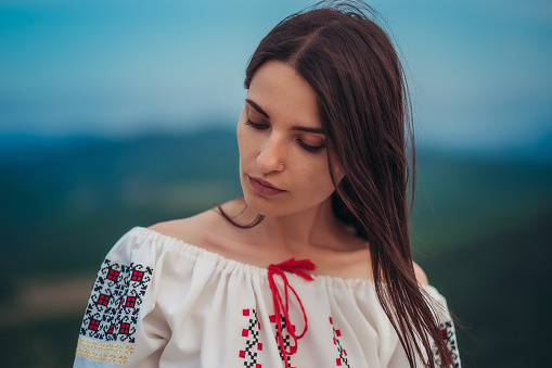 https://media.istockphoto.com/id/1208584172/photo/atractive-woman-in-traditional-romanian-costume-on-mountain-green-blurred-background-outdoor.jpg?b=1&s=170667a&w=0&k=20&c=U0hyzBkCgXSEpdvc-zAOGtmFva0elZIgr0HQTFg5wrc=