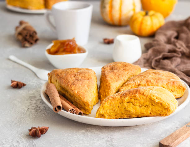 Traditional English cuisine. Breakfast with spicy pumpkin scones, a cup of tea and milk. Traditional English cuisine. Breakfast with spicy pumpkin scones, a cup of tea and milk. scone photos stock pictures, royalty-free photos & images