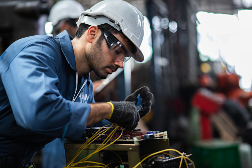 Ingeniero de trabajadores manuales de pie en un molino de aluminio y trabajando juntos. equipos profesionales usados. Trabajadores manuales que cooperan mientras miden un dispositivo electrónico. photo