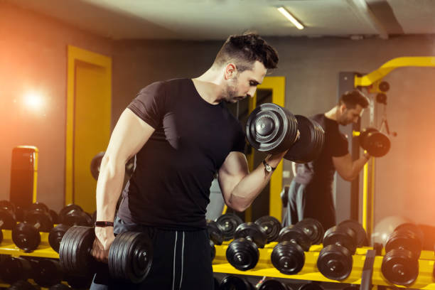 istock Handsome muscular man working out hard at gym 1208587899