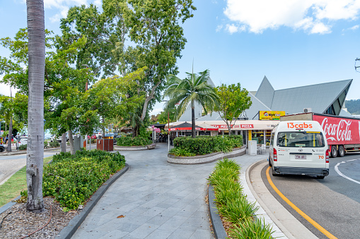 Tourists are walking and shopping at Airlie Beach Main Street in the tropical Whitsundays, Australia.