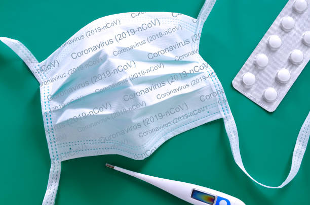 istock White face mask with the inscription Coronavirus (2019-nCoV) is lying on a blue background 1208593859