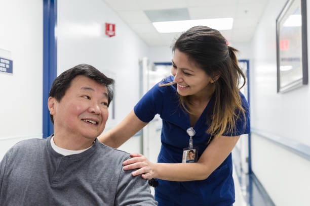 istock Cheerful nurse talks with senior man 1208596915
