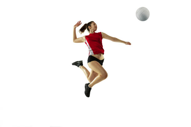 Young female volleyball player isolated on white studio background in flight and motion In jump and flight. Young female volleyball player isolated on white studio background. Woman in sportswear and sneakers training, playing. Concept of sport, healthy lifestyle, motion and movement. volleyball ball volleying isolated stock pictures, royalty-free photos & images