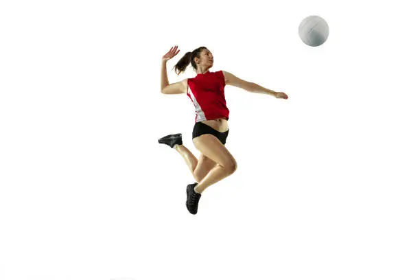 Photo of Young female volleyball player isolated on white studio background in flight and motion