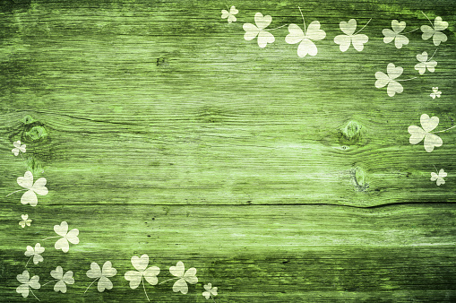Shamrocks sobre la mesa de madera verde un símbolo og St. Patricks Day. Bbanner con borde de esquina de shamrocks. Patrón texturizado. photo