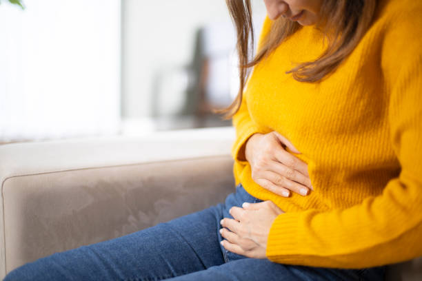 istock Young woman suffering PMS pain on sofa 1208604689