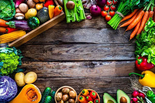 Photo of Healthy fresh vegetables border on wooden table. Copy space.