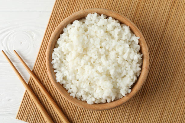 istock Bowl with boiled rice and chopsticks on wooden background, top view 1208606484