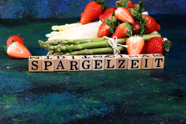 istock White and green asparagus with strawberries on rustic background with Spargelzeit wooden letter. 1208607865