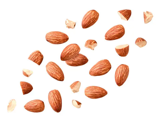 Peeled almonds whole and pieces flying on a white background. Isolated