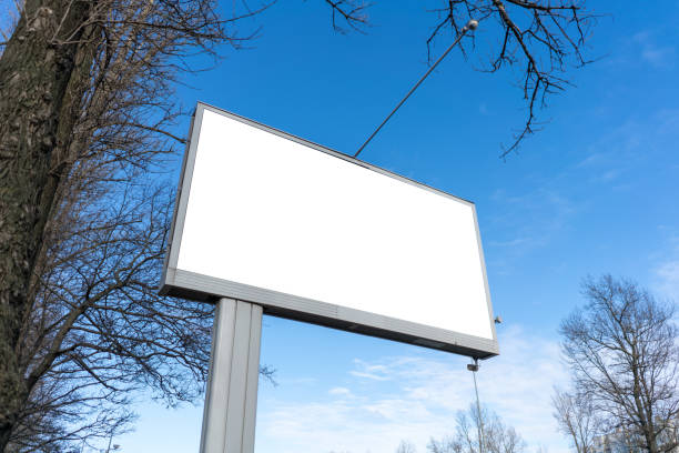 istock Billboard on a background of blue sky and trees. Wide angle shot down view. With white space for mock-up posters 1208610315