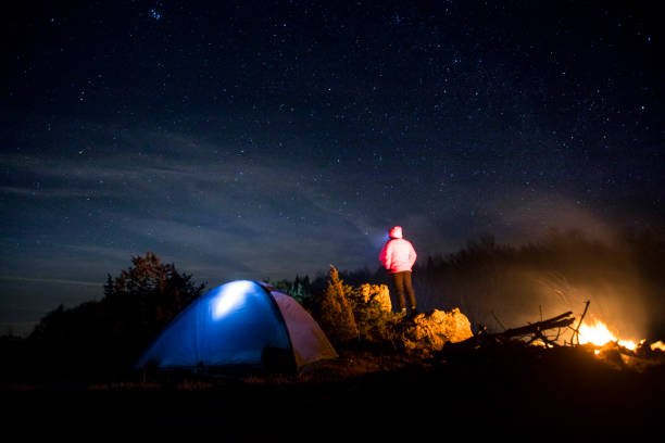 istock Adult Man Watching Night Sky While Camping in Nature 1208610726