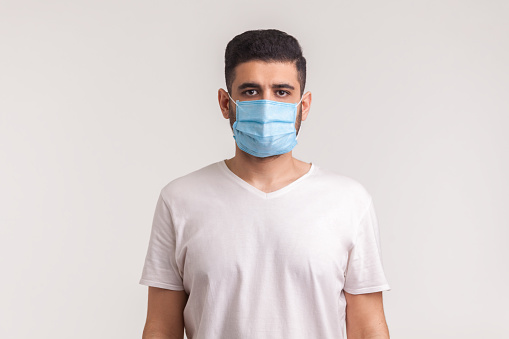 Protección contra enfermedades contagiosas, coronavirus. Hombre que usa mascarilla higiénica para prevenir infecciones, enfermedades respiratorias transmitidas por el aire photo