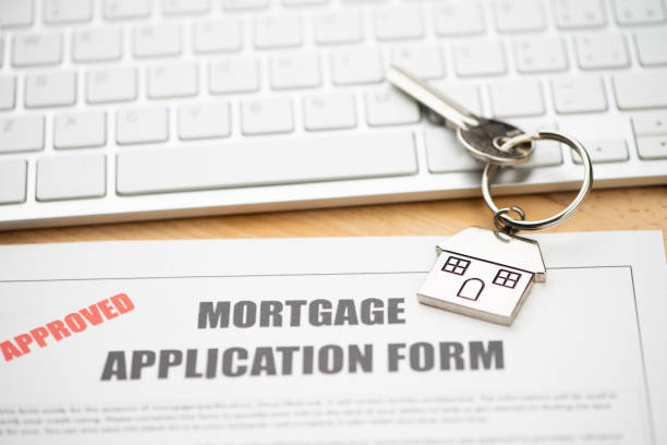 istock Approved mortgage loan agreement application with house shaped keyring 1208611592