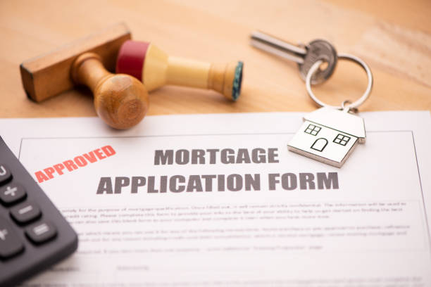 istock Approved mortgage loan agreement application with house shaped keyring 1208611645