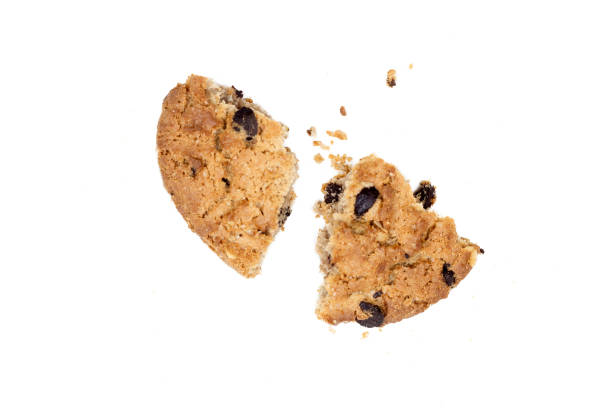 istock Close up of chocolate chip cookie pieces with crumbs isolated on white background. 1208612607