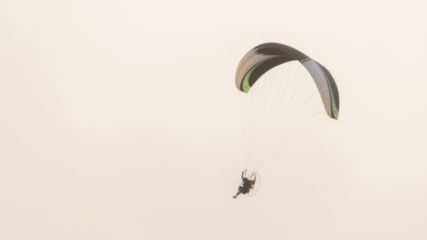 istock A paramotor gliding with people flying in the sky beautifully 1208614742