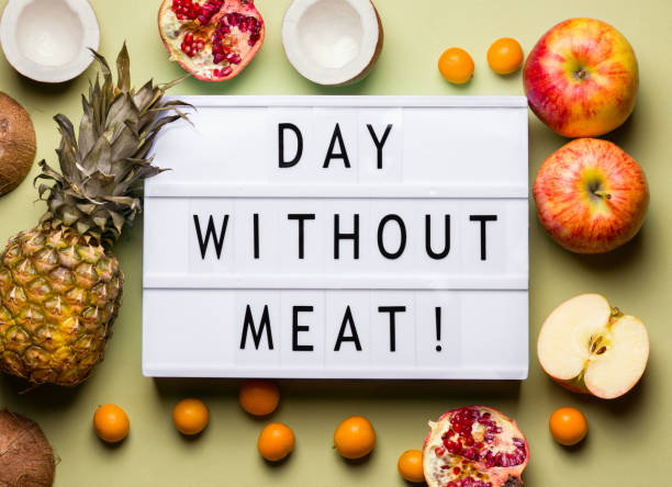istock Day Without Meat lightbox inscription. next to fruit on a green background. 1208614900