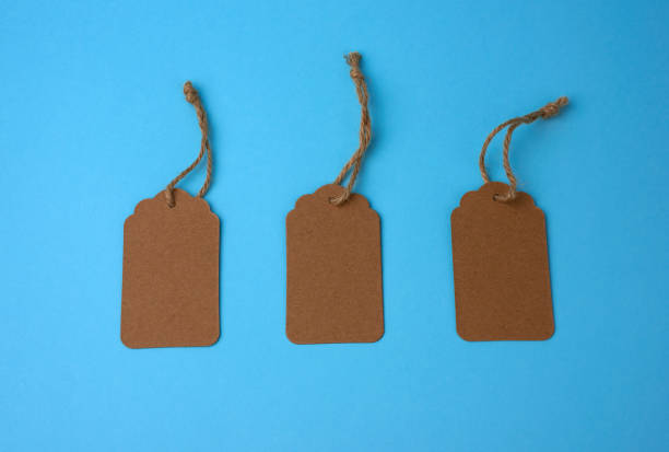 istock Empty brown paper tags tied with white string. Price tag, gift tag, sale tag 1208615753