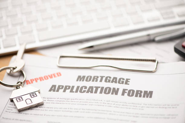 istock Approved mortgage loan agreement application with house shaped keyring 1208615829