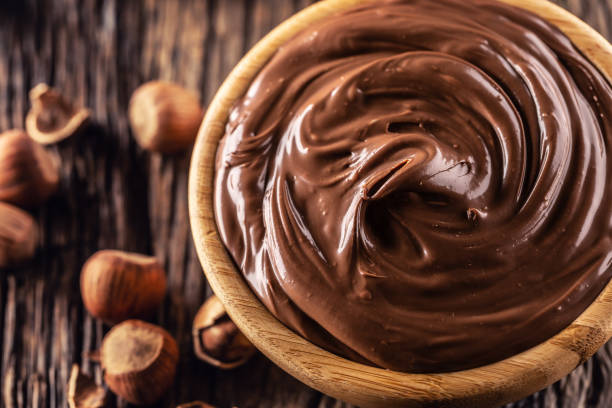 istock Chocolate hazelnut spread in wooden bowl - Close up 1208617252