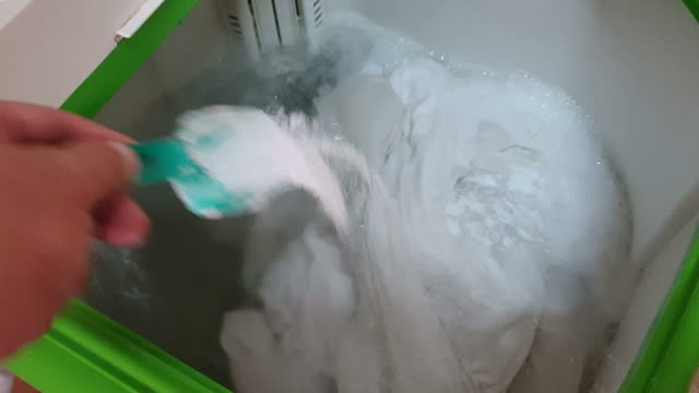 Man fill washing powder into washing machine