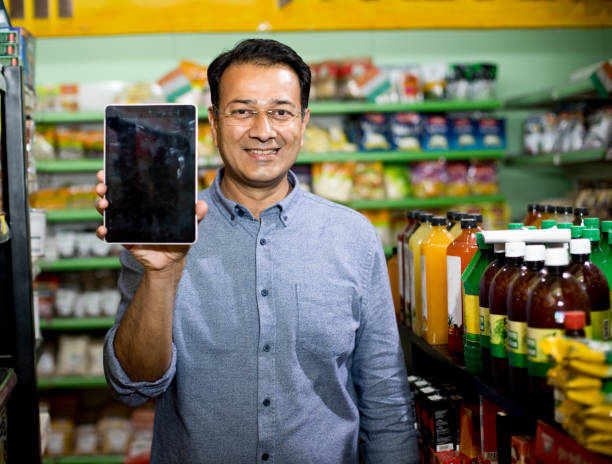 happy man holding digital tablet at supermarket - asian ethnicity shopping mall supermarket store imagens e fotografias de stock