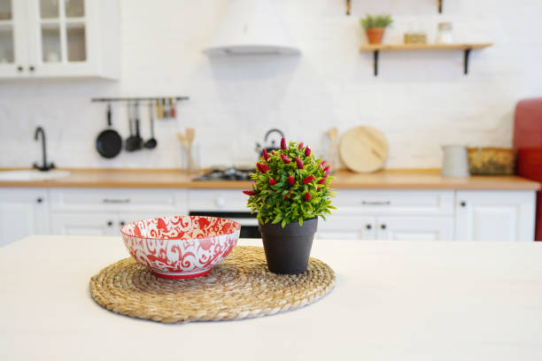 istock Ripe red hot chili peppers on a tree in a decorative pot on the table in the kitchen 1208623601