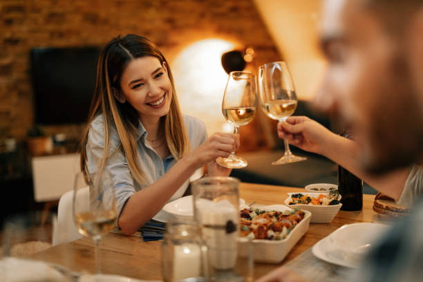 istock Happy woman toasting with friends during dinner at dining table. 1208624695