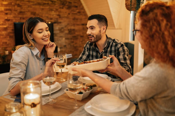istock Group of young people enjoying in dinner at dining table at home. 1208625321