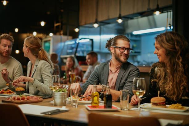 istock Group of friends sitting in restaurant and eating dinner. 1208626507