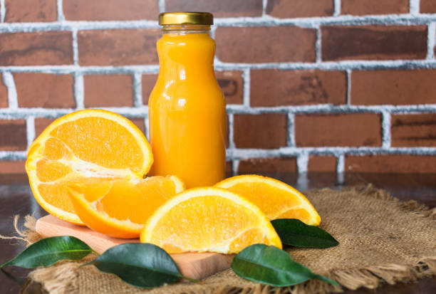 istock Orange juice in a bottle on a wall background. 1208628413