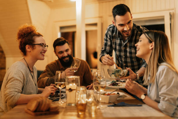 istock Group of happy friends having fun while eating dinner in dining room. 1208628505