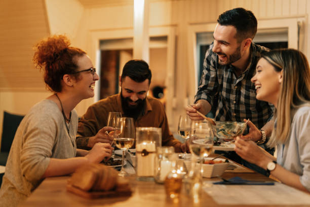 istock Young cheerful people having fun during dinner in dining room. 1208628507